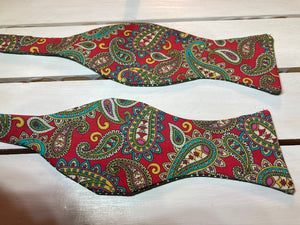 Red and olive Green paisley  self tie bow tie with classic small olive green polka dot print on reverse.